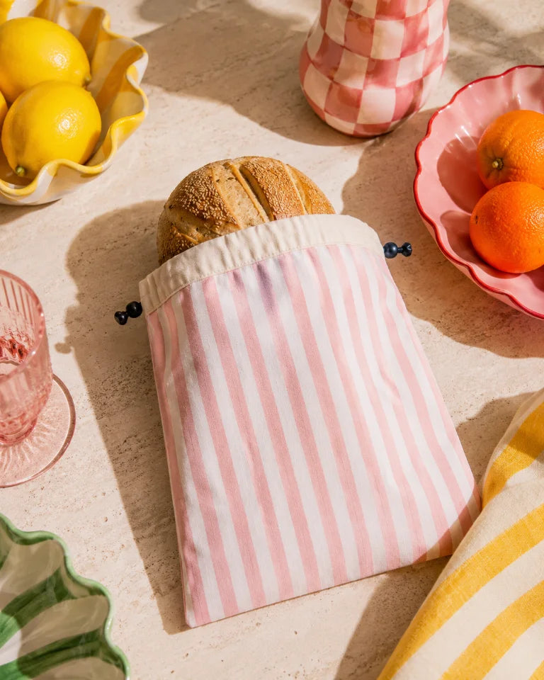 Crummy linen bread bag standing on a kitchen bench with a loaf inside