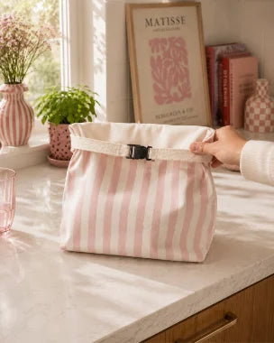 Hands pulling the drawstring of a Crummy bread bag closed